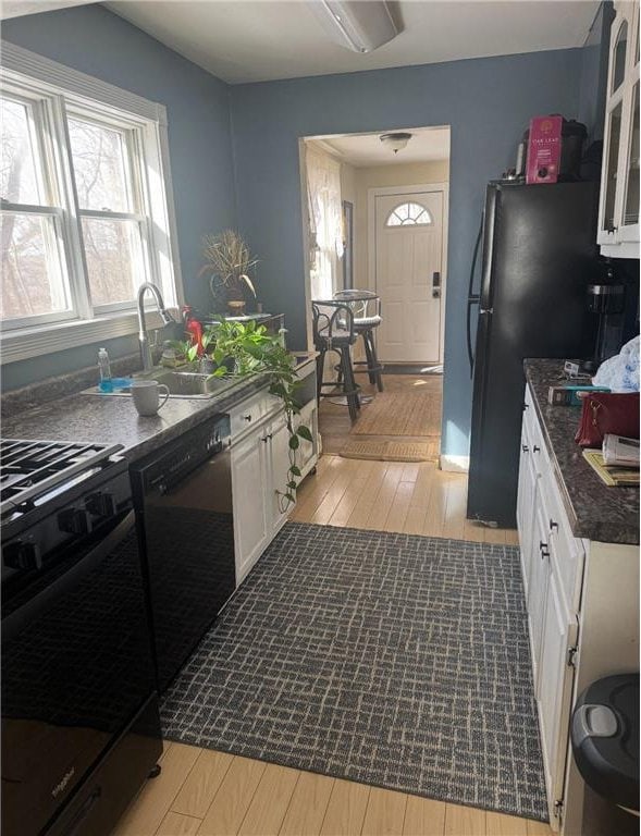 338 S Jefferson St, Saint Croix Falls, WI 54024 - kitchen featuring range, dishwasher, light wood-type flooring, and white cabinetry