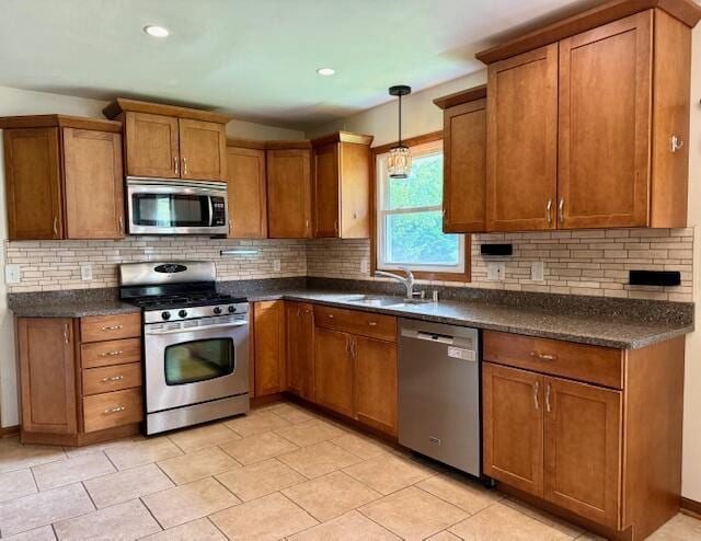 W254S6620 Ridge Rd, Waukesha, WI 53189 - kitchen with stainless steel appliances, dark countertops, brown cabinetry, tasteful backsplash, and recessed lighting