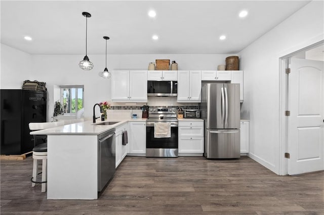 4271 220th St, Cadott, WI 54727 - kitchen with appliances with stainless steel finishes, a peninsula, white cabinets, dark wood finished floors, and recessed lighting
