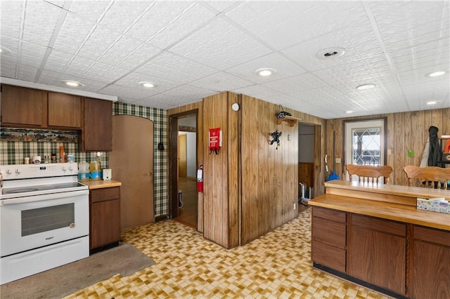 4271 220th St, Cadott, WI 54727 - kitchen featuring electric stove, light flooring, brown cabinetry, light countertops, and wood walls