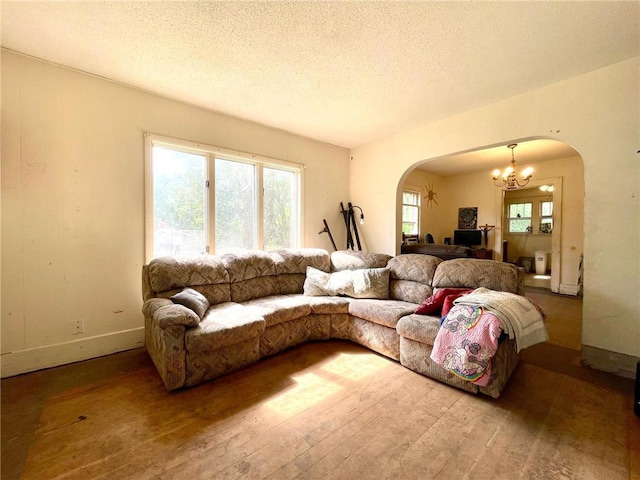 306 E Race Ave, Elmwood, WI 54740 - living room featuring arched walkways, a chandelier, wood-type flooring, and a textured ceiling