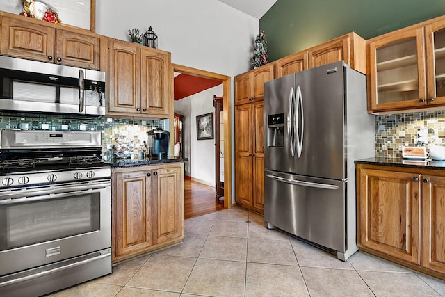 6320 10th Pl, Kenosha, WI 53144 - kitchen with appliances with stainless steel finishes, tasteful backsplash, glass insert cabinets, light tile patterned flooring, and brown cabinets