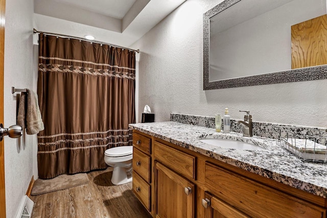 6320 10th Pl, Kenosha, WI 53144 - full bathroom with wood finished floors, a textured wall, vanity, a shower with shower curtain, and a baseboard radiator