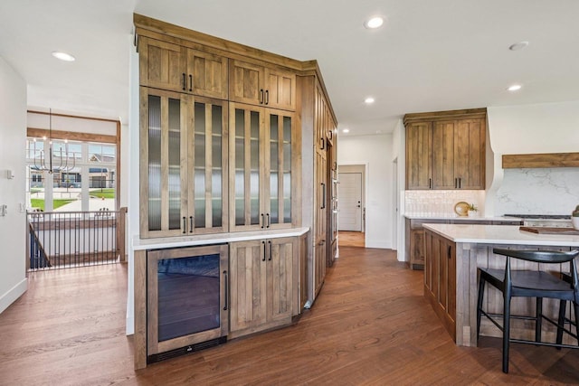 3330 Colton Way, Sun Prairie, WI 53590 - kitchen with beverage cooler, brown cabinets, light countertops, dark wood finished floors, and recessed lighting