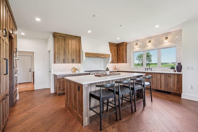 3330 Colton Way, Sun Prairie, WI 53590 - kitchen with premium range hood, a center island, brown cabinetry, backsplash, and recessed lighting
