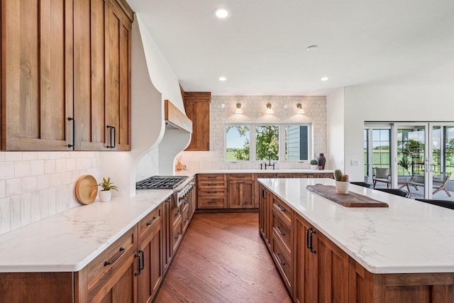 3330 Colton Way, Sun Prairie, WI 53590 - kitchen featuring brown cabinets, plenty of natural light, stainless steel gas cooktop, light stone counters, and recessed lighting
