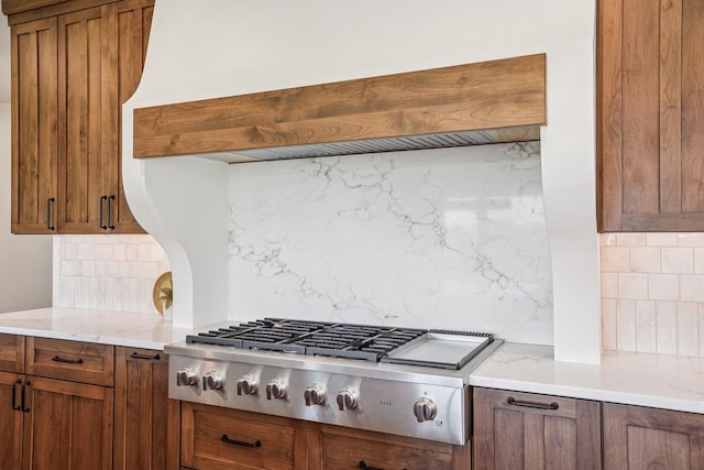 3330 Colton Way, Sun Prairie, WI 53590 - kitchen with tasteful backsplash, stainless steel gas cooktop, brown cabinetry, and custom exhaust hood