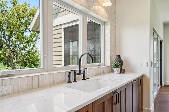3330 Colton Way, Sun Prairie, WI 53590 - kitchen with light stone counters, brown cabinets, and dark wood finished floors