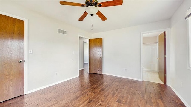 701 Devils Ln, Walworth, WI 53184 - unfurnished bedroom with wood finished floors, connected bathroom, and a ceiling fan