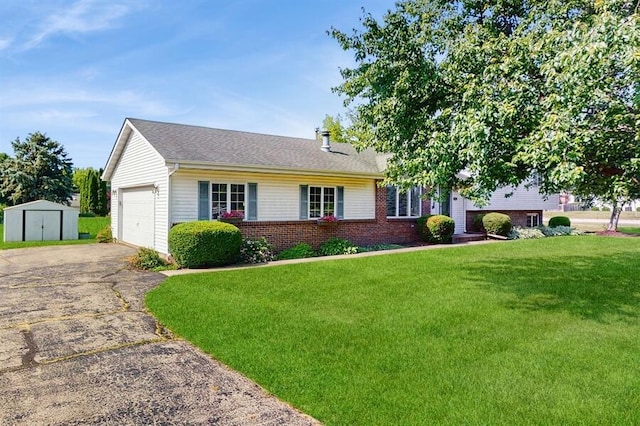 701 Devils Ln, Walworth, WI 53184 - view of front of house featuring a shed, a front lawn, brick siding, asphalt driveway, and a garage