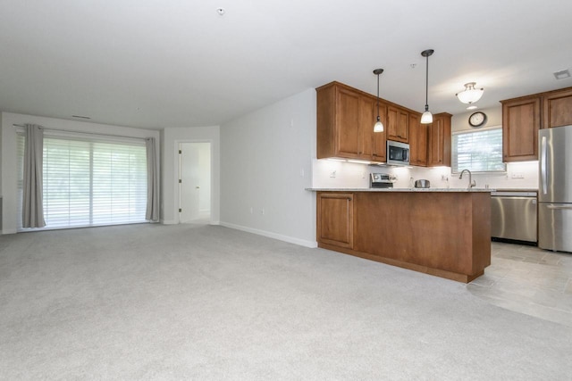 18520 Emerald Cir Unit D, Brookfield, WI 53045 - kitchen featuring stainless steel appliances, brown cabinetry, light carpet, decorative light fixtures, and a peninsula