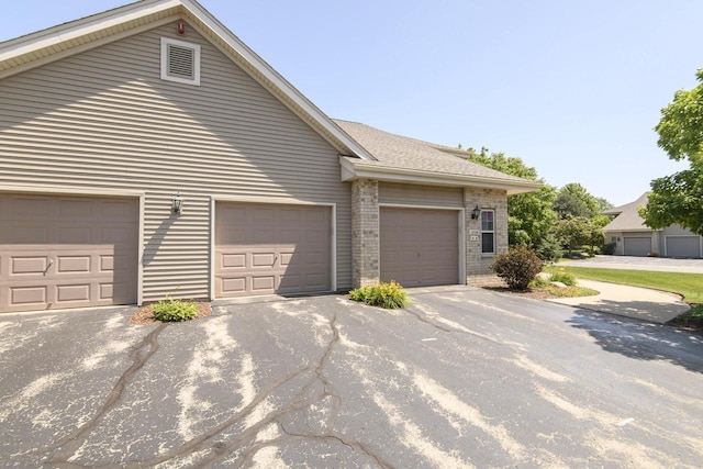18520 Emerald Cir Unit D, Brookfield, WI 53045 - view of side of property featuring brick siding, a garage, and driveway