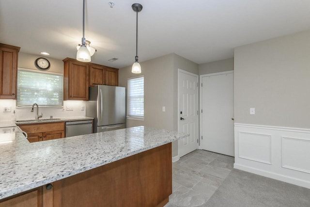 18520 Emerald Cir Unit D, Brookfield, WI 53045 - kitchen with stainless steel appliances, brown cabinetry, a peninsula, light stone countertops, and pendant lighting