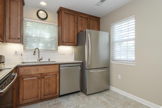 18520 Emerald Cir Unit D, Brookfield, WI 53045 - kitchen featuring appliances with stainless steel finishes, brown cabinets, tasteful backsplash, light stone countertops, and recessed lighting