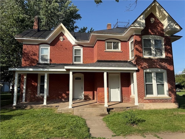 15 S Culver St, Chippewa Falls, WI 54729 - view of front facade with a chimney, a porch, brick siding, and a front yard