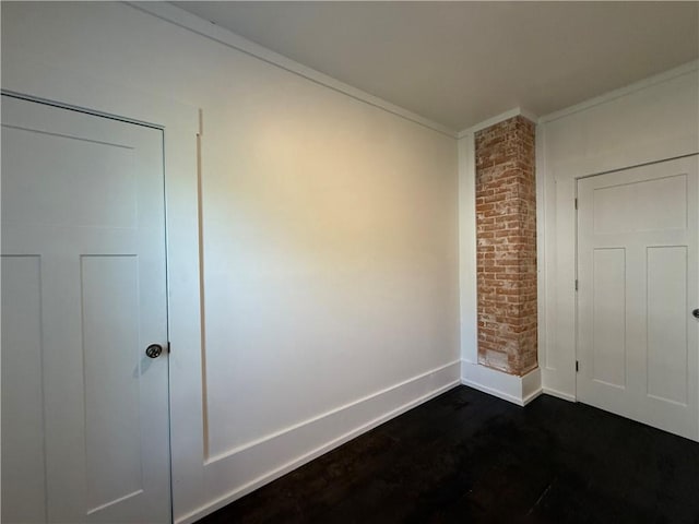 15 S Culver St, Chippewa Falls, WI 54729 - empty room featuring ornamental molding, dark wood-style floors, and brick wall