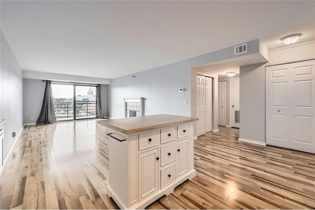 26 10th St Unit 1104, Saint Paul, MN 55102 - kitchen featuring light wood finished floors, open floor plan, white cabinetry, and a center island
