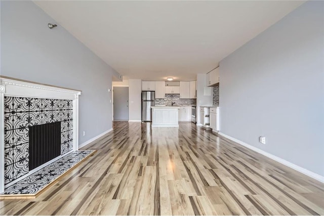 26 10th St Unit 1104, Saint Paul, MN 55102 - unfurnished living room featuring light wood-style flooring and a tile fireplace