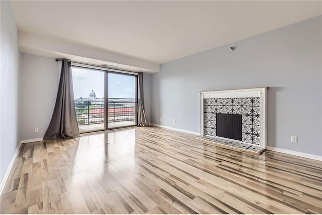 26 10th St Unit 1104, Saint Paul, MN 55102 - unfurnished living room featuring wood finished floors and a tile fireplace