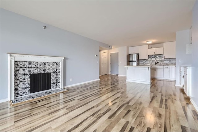 26 10th St Unit 1104, Saint Paul, MN 55102 - unfurnished living room featuring light wood finished floors and a tile fireplace