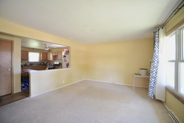 8750 W Hustis St, Milwaukee, WI 53224 - unfurnished living room with baseboard heating, light carpet, and ceiling fan