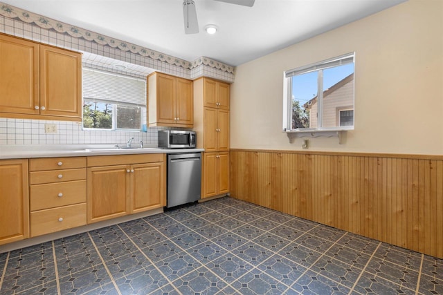 114 S Adam St, South Beloit, IL 61080 - kitchen featuring stainless steel appliances, wainscoting, a ceiling fan, light countertops, and wooden walls