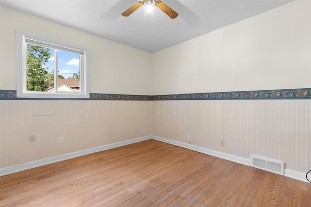 114 S Adam St, South Beloit, IL 61080 - empty room featuring wainscoting, wood finished floors, and ceiling fan