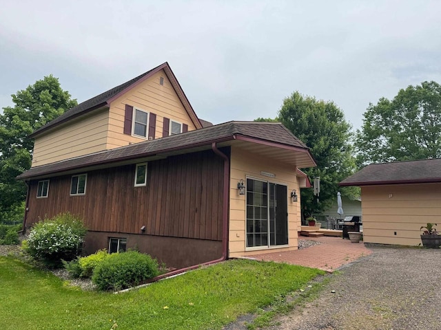 710 Jefferson St, Merrill, WI 54452 - view of side of home featuring roof with shingles, a yard, and a patio area