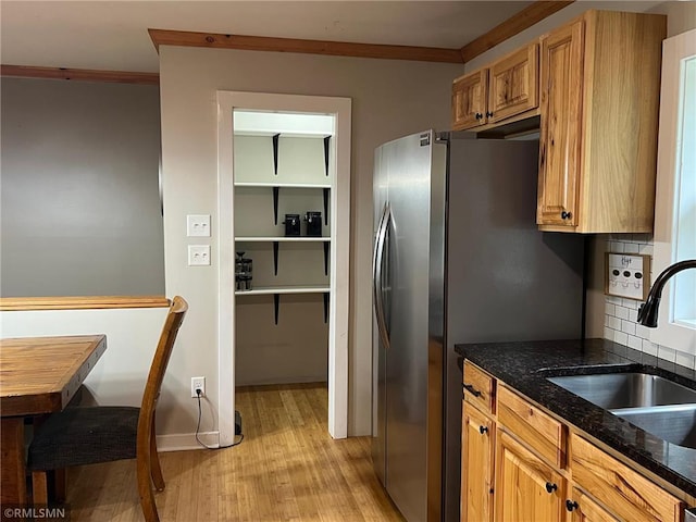 1283 230th Ave, Luck, WI 54853 - kitchen with light wood finished floors, ornamental molding, stainless steel refrigerator with ice dispenser, dark stone countertops, and brown cabinets