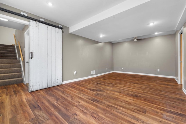 8020 Ridgeway Dr, Burlington, WI 53105 - below grade area with a barn door, ceiling fan, dark wood-type flooring, stairway, and recessed lighting