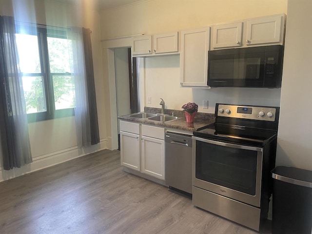 510 S Vine Ave, Marshfield, WI 54449 - kitchen with appliances with stainless steel finishes, light wood finished floors, dark countertops, and white cabinets
