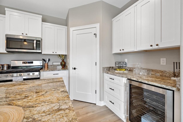 1883 Woodland Way, Slinger, WI 53086 - kitchen with appliances with stainless steel finishes, wine cooler, light wood-style floors, and white cabinets
