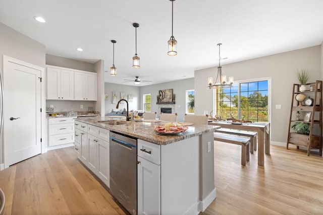 1883 Woodland Way, Slinger, WI 53086 - kitchen with stainless steel dishwasher, ceiling fan, light wood-type flooring, plenty of natural light, and recessed lighting