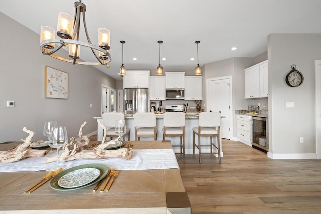 1883 Woodland Way, Slinger, WI 53086 - dining room with beverage cooler, a chandelier, light wood-style flooring, and recessed lighting