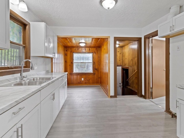 5751 N 38th St, Milwaukee, WI 53209 - kitchen with healthy amount of natural light, light wood finished floors, light countertops, wooden walls, and a textured ceiling