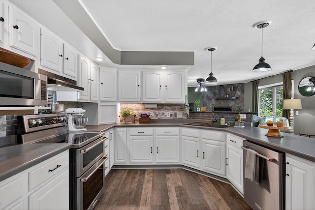 5111 Timberland Trl, Wisconsin Rapids, WI 54494 - kitchen with stainless steel appliances, decorative backsplash, dark countertops, and dark wood-style floors