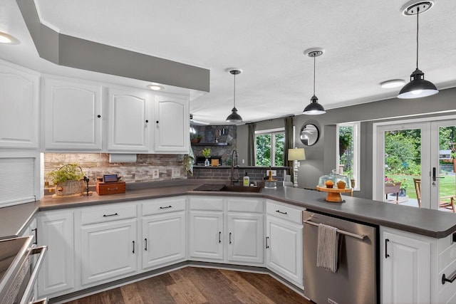 5111 Timberland Trl, Wisconsin Rapids, WI 54494 - kitchen featuring stainless steel dishwasher, dark countertops, decorative backsplash, a peninsula, and dark wood-type flooring