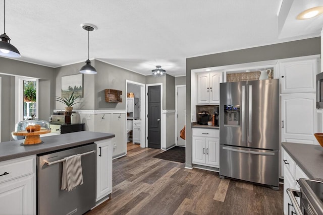 5111 Timberland Trl, Wisconsin Rapids, WI 54494 - kitchen with stainless steel appliances, dark countertops, dark wood-style floors, white cabinets, and ornamental molding