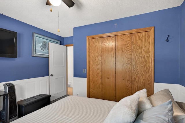 5111 Timberland Trl, Wisconsin Rapids, WI 54494 - bedroom with wainscoting, a textured ceiling, a closet, a ceiling fan, and a decorative wall