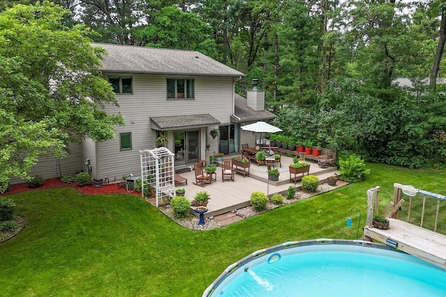 5111 Timberland Trl, Wisconsin Rapids, WI 54494 - rear view of house featuring a deck, a chimney, an outdoor pool, and an outdoor hangout area