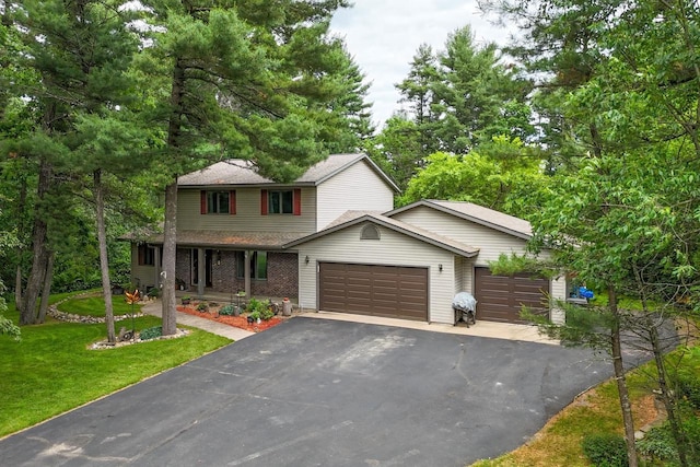 5111 Timberland Trl, Wisconsin Rapids, WI 54494 - view of front of house with a garage, driveway, a front lawn, covered porch, and roof with shingles