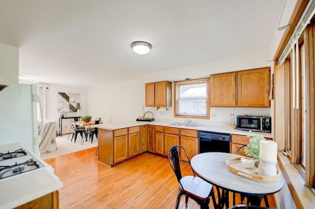 851 Hennessy St, Oshkosh, WI 54904 - kitchen with black dishwasher, freestanding refrigerator, a peninsula, light countertops, and light wood-style floors