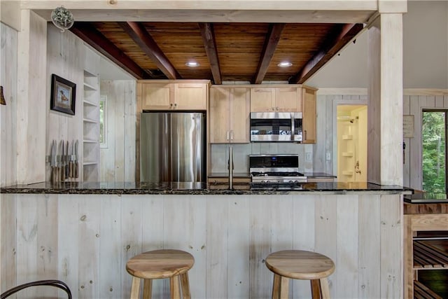 8674 Nor Wis Rd, Hayward, WI 54843 - kitchen with stainless steel appliances, a wood ceiling with exposed beams, dark stone counters, a kitchen breakfast bar, and wooden walls