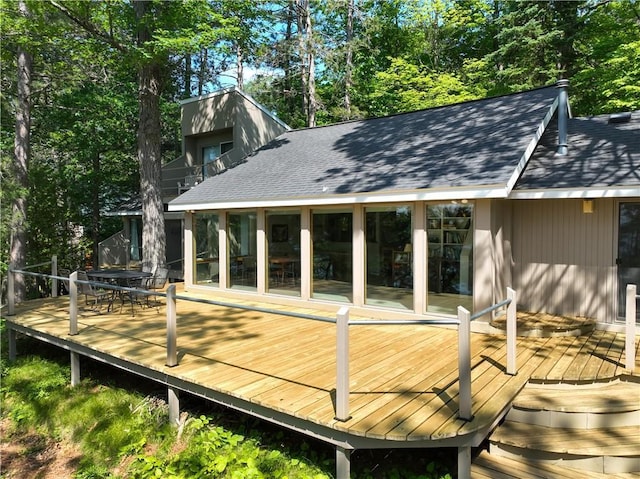8674 Nor Wis Rd, Hayward, WI 54843 - wooden terrace with outdoor dining area and view of wooded area