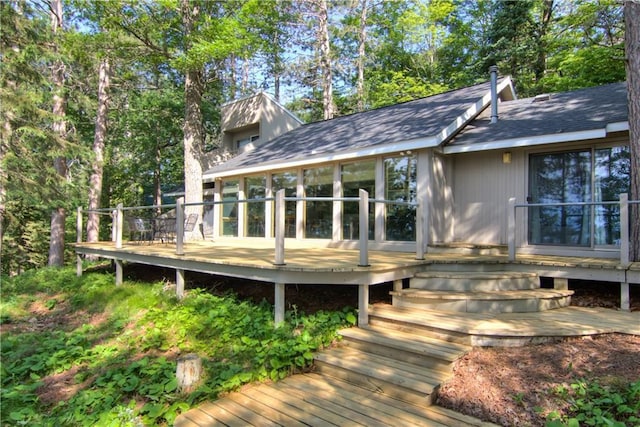 8674 Nor Wis Rd, Hayward, WI 54843 - rear view of house featuring a wooden deck, a sunroom, and roof with shingles