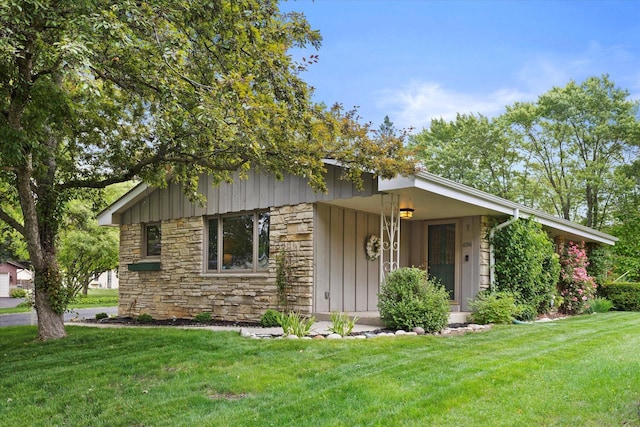 6196 N River Trail Dr, Milwaukee, WI 53225 - mid-century home featuring stone siding, a front lawn, and board and batten siding