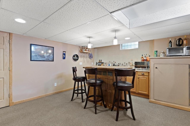 6196 N River Trail Dr, Milwaukee, WI 53225 - indoor bar featuring light colored carpet, a paneled ceiling, stainless steel microwave, and decorative light fixtures