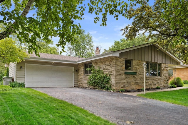 6196 N River Trail Dr, Milwaukee, WI 53225 - ranch-style home with a chimney, asphalt driveway, stone siding, an attached garage, and a front yard