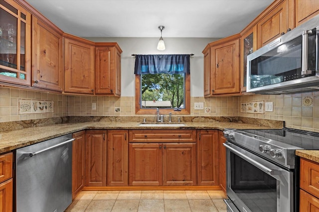 6196 N River Trail Dr, Milwaukee, WI 53225 - kitchen featuring appliances with stainless steel finishes, brown cabinetry, and tasteful backsplash