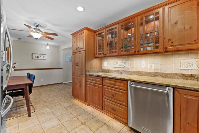 6196 N River Trail Dr, Milwaukee, WI 53225 - kitchen with stainless steel appliances, brown cabinetry, ceiling fan, backsplash, and glass insert cabinets